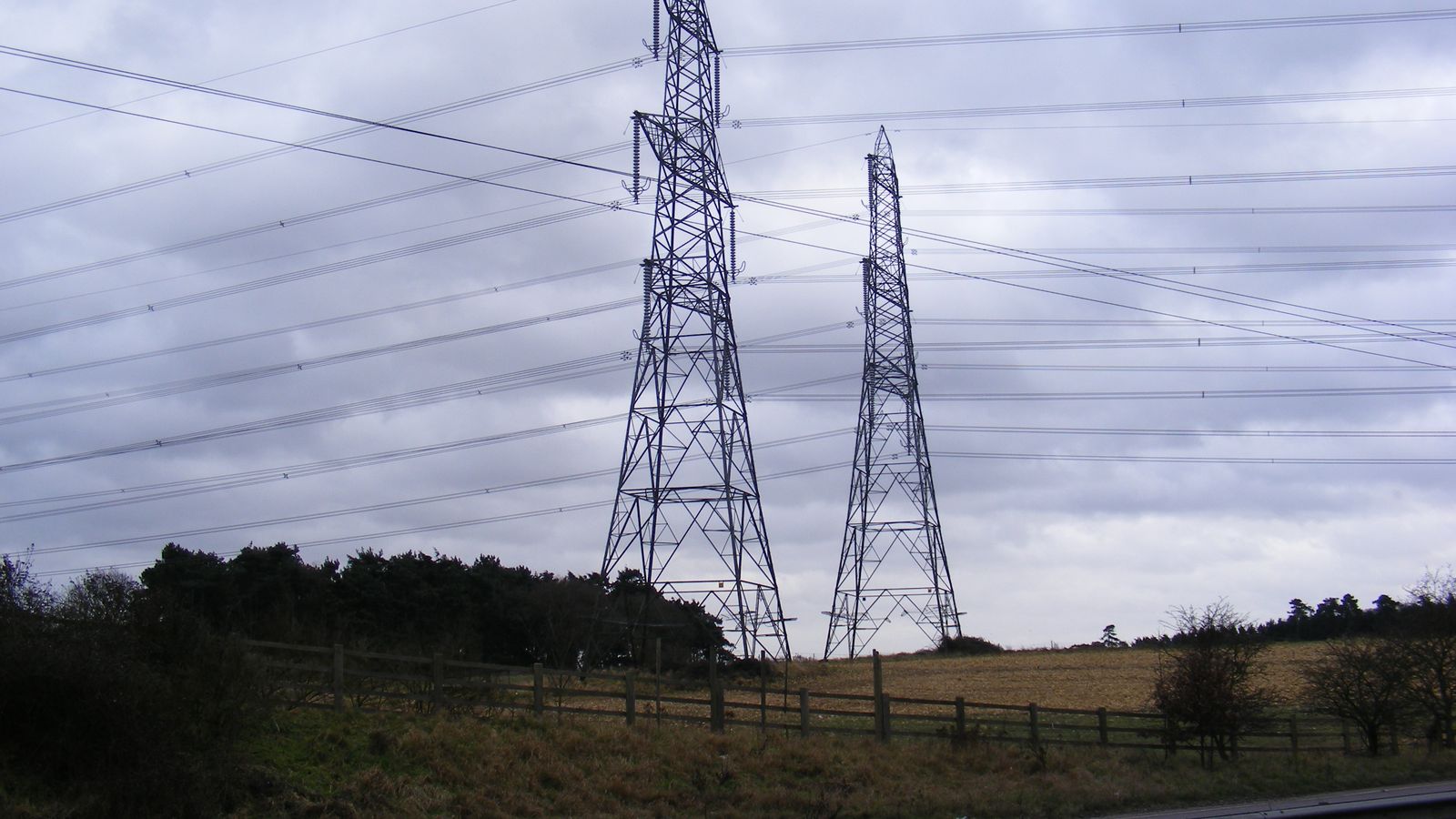 Electricity pylons and overhead power lines crossing farmland in England