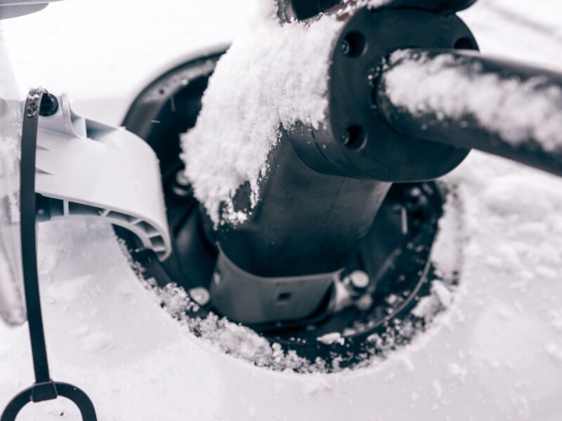 A charging cable plugged into a Hyundai IONIQ covered in snow